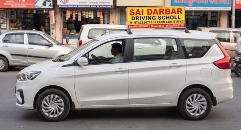 White Suzuki Ertiga Side Profile Driving - Sai Darbar Motor Training School Thane